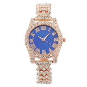 Detail of rose gold rhinestone watch featuring a blue dial with Roman numeral indices