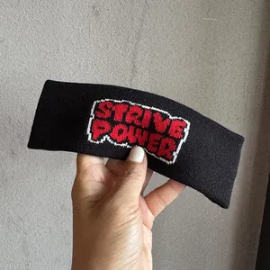 Détail du bandeau de sport tricoté noir avec lettrage Strive Power style pixel