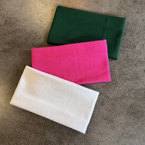 Detailed view of three knitted sports headbands in green, rose red and white textures
