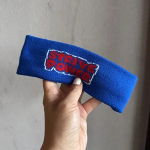 Détail macro du bandeau en maille marine avec broderie rouge Strive Power en lettres