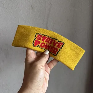 Détail du bandeau de sport en tricot jaune avec broderie pixel Strive Power