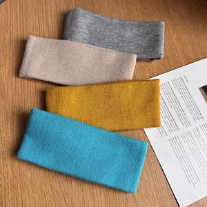 Vue détaillée de quatre bandeaux en tricot côtelé en gris rose jaune et bleu avec texture