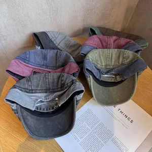 Vintage washed cotton paneled beret hat with adjustable metal buckle on wood background
