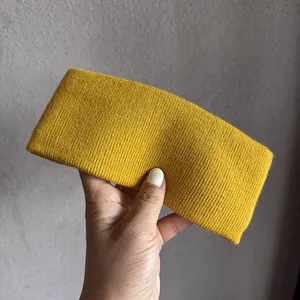Gros plan du bandeau en tricot côtelé jaune gingembre montrant la texture et l'élasticité