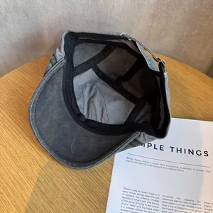 Detail view of washed canvas beret featuring inner sweatband and metal adjustable buckle