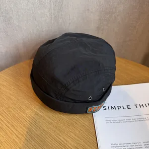 Detail of black ripstop nylon docker hat with RIDER embroidery and metal eyelet