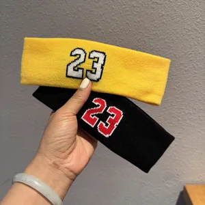 Close-up of yellow and black elastic knitted sports headbands with number 23 embroidery