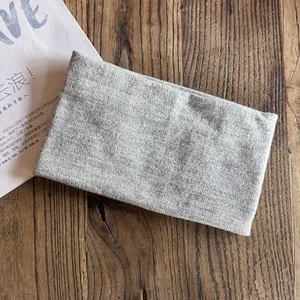 Close-up of grey knitted headband with soft wool texture on rustic wooden background