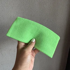 Gros plan sur la texture en tricot côtelé vert fluo du bandeau de sport élastique