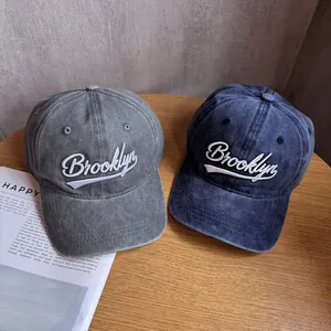 Vintage washed baseball caps in grey and blue with Brooklyn embroidery on wooden table