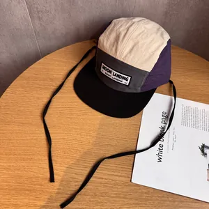 Détail de la casquette camper 5 pans multicolore avec broderie Moon Landing sur bois
