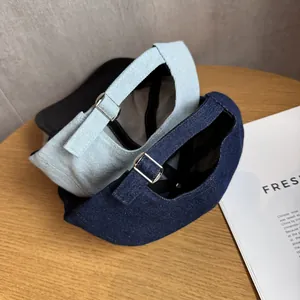 Detail of adjustable silver metal buckle and denim texture on blue baseball caps