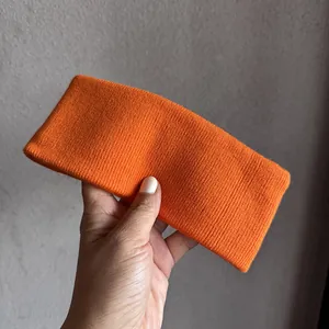 Vue détaillée d'un bandeau de sport en tricot orange vif montrant la texture du tissu