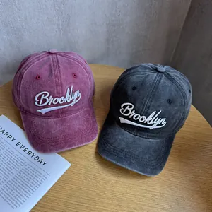 Detail view of washed vintage baseball caps with Brooklyn embroidery in rose and grey colors