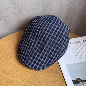 Vue détaillée de la casquette plate à carreaux bleus et blancs sur une table en bois