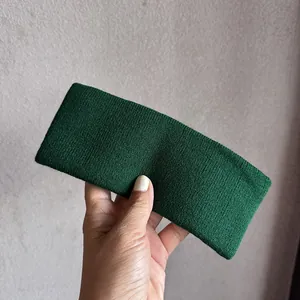 Détail d'un bandeau de sport en tricot vert foncé montrant la texture des mailles