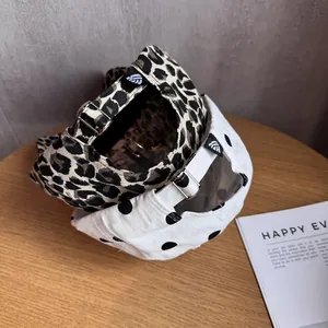 Vintage leopard and polka dot baseball caps with adjustable metal buckle on wood table