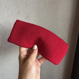 Détail du bandeau en tricot côtelé rouge montrant la texture douce et les motifs de tissage