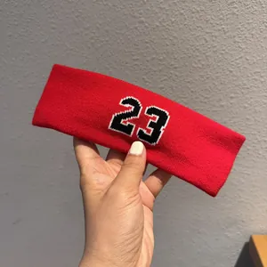 Close-up of a red knitted sports headband featuring a detailed number 23 embroidery