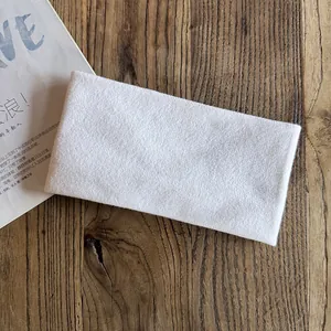 Close-up of white soft knitted headband texture on natural wood grain surface