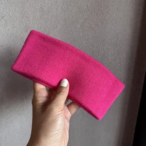 Vue détaillée du bandeau tricoté rose fuchsia avec une texture côtelée douce et souple