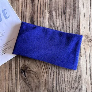 Detailed close-up of dark blue knitted headband showing thick loopy fabric texture