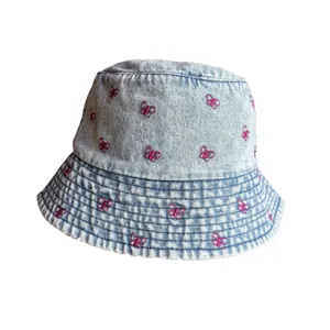 Chapeau bob en jean bleu avec broderie papillon rose et bords effilochés sur fond blanc