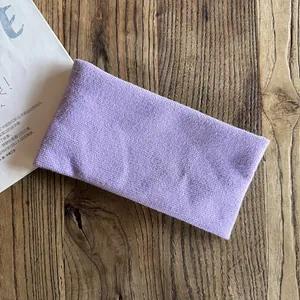 Detailed knit texture of a light purple minimalist headband on a wooden background