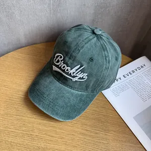 Detail of vintage washed green cotton baseball cap with white Brooklyn embroidery