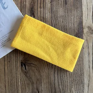Detailed view of yellow knitted headband on wood texture for sports and daily wear