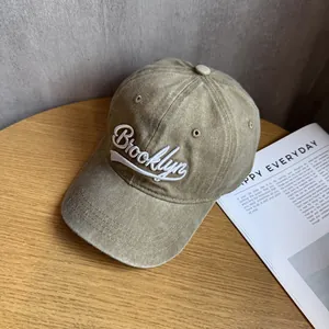Close-up of vintage washed baseball cap with Brooklyn embroidery on wooden surface
