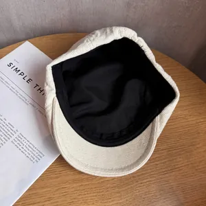 Vue détaillée de l'intérieur d'un béret beige montrant la doublure noire et la texture