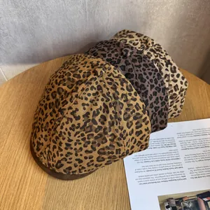 Retro leopard print beret hat for women in three stylish brown tones on a wooden table