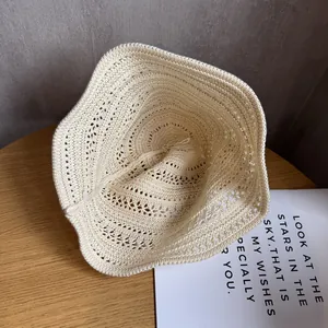 Close-up of the delicate hollow woven texture on a cream summer crochet bucket hat