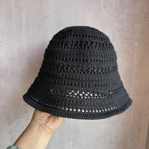 Close-up of black hollow knit bucket hat showing detailed breathable crochet pattern
