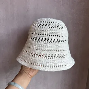 Close-up of hand-crocheted white bucket hat with breathable hollow lace texture