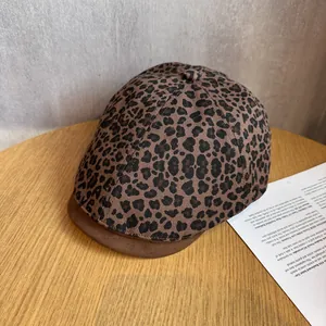 Detailed view of leopard print beret with brown suede brim and fine fabric texture
