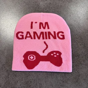 Detail of pink knitted beanie with red I'M GAMING text and controller jacquard pattern