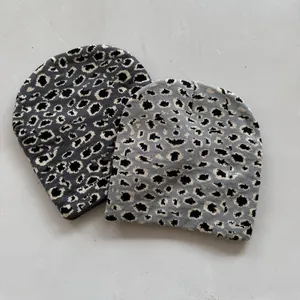Leopard print knitted beanies in grey and beige tones for autumn and winter warmth