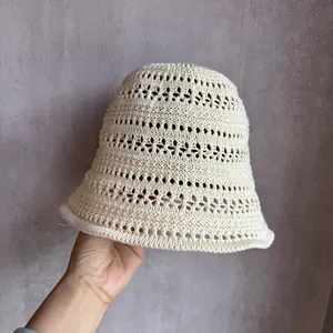 Detailed close-up of cream knit hollow bucket hat showing intricate crochet pattern and texture