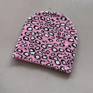 Detailed close-up of pink leopard print jacquard knit beanie for winter street style