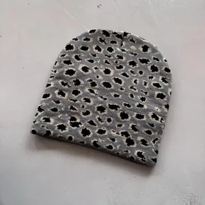 Detailed view of leopard print knit texture and pattern on a warm winter beanie hat