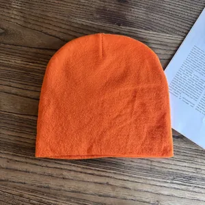 Tessuto a maglia dettagliato di un berretto arancione vivace su fondo in legno