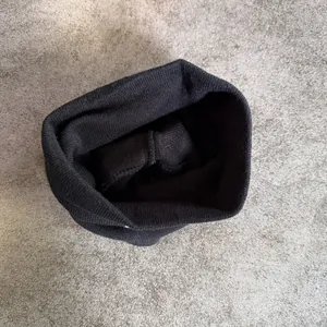 Close-up of a black rib-knit beanie showing the thick texture and clean inner stitching