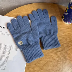 Detailed knit texture and cute bear embroidery on blue winter touchscreen gloves