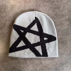 Détail d'un bonnet en maille gris avec un grand motif d'étoile noire et une texture douce