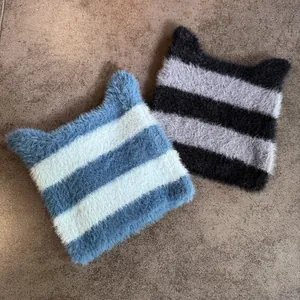 Primer plano de gorros de punto a rayas con orejas de gato y textura de felpa suave
