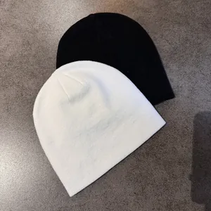 Détail du bonnet en maille étoile montrant la texture douce noire et blanche d'hiver