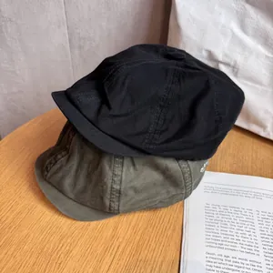 Detailed texture of cotton sailor hats in black and green with minimalist embroidery