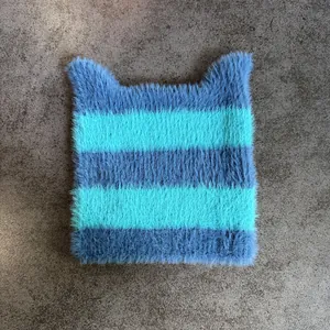 Primer plano de gorro con orejas de gato a rayas azules y textura de lana suave